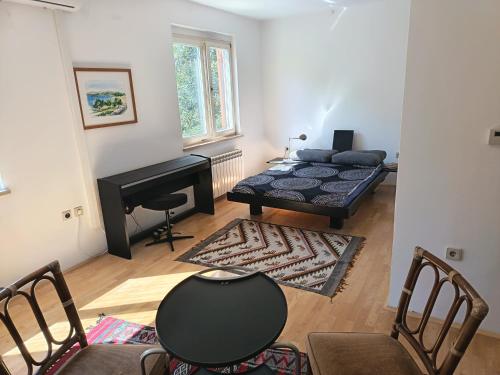 a living room with a bed and a piano at Pine Breeze in Punat
