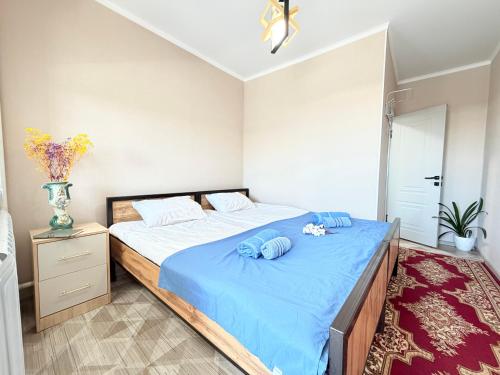 a bedroom with a large bed with blue sheets at Like House Karakol in Karakol