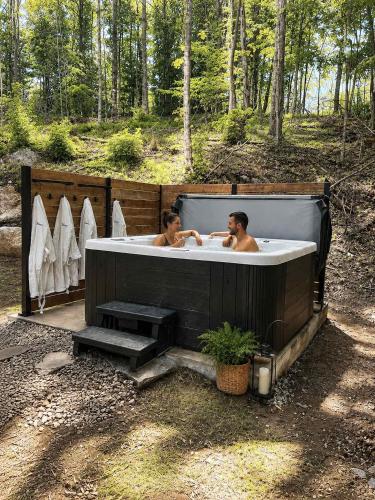 two people in a bath tub in a forest at Spa & Babyfoot - Chalet BOREA in Saint-Faustin