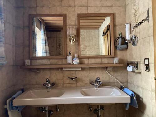 a bathroom with two sinks and a mirror at Jagerhäusl in Fügen