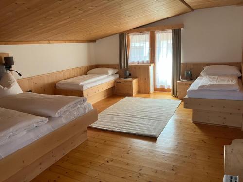 a bedroom with two beds and a large window at Jagerhäusl in Fügen