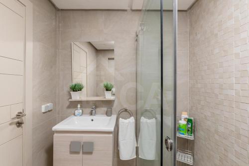a bathroom with a shower and a sink and a mirror at Ocean & Sunset View Pool & Parking in Tamraght Ouzdar