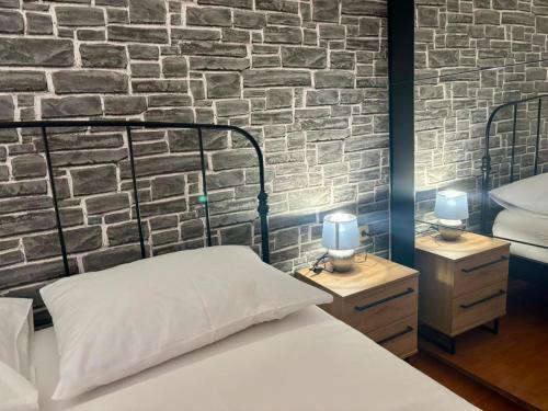 a bedroom with a brick wall with a bed and two lamps at Cozy apartment Ivana in Gornji Karin