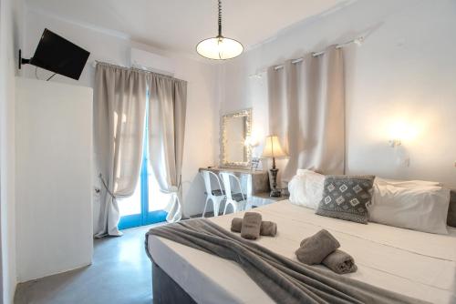 a bedroom with a large bed with two stuffed animals on it at Hotel Pleasure Blackbeach Santorini in Perissa