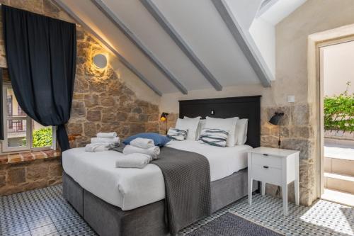 two beds in a room with a stone wall at Villa Pauletta in Split