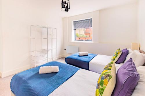 a bedroom with two beds and a window at Modern City Centre Flat in Norwich