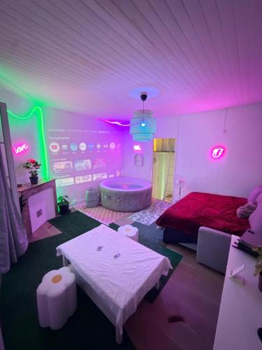 a room with a bed and a tub with pink lights at Un Jacuzzi dans le centre in Bordeaux