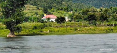 a house on a hill next to a river at GTR Royal Palace cottage in Wodapatti