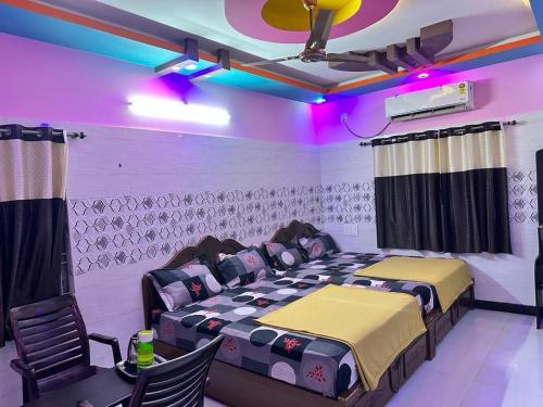 a room with two beds and purple lights at GTR Royal Palace cottage in Wodapatti