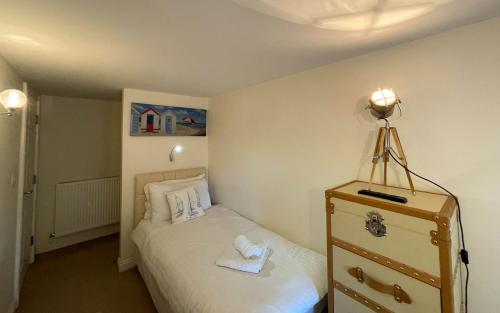 a small bedroom with a bed and a dresser at Spinnaker, Whitehall in Ardeonaig