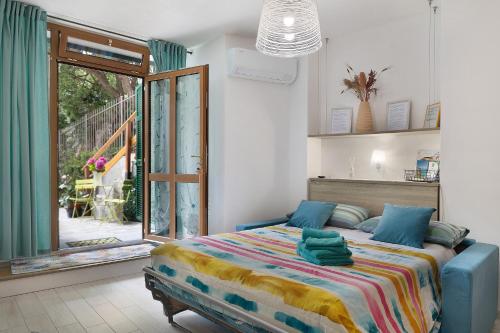 a bedroom with a bed and a sliding glass door at Quercia -in Caruggiu di Via Vecchia in Orco Feglino