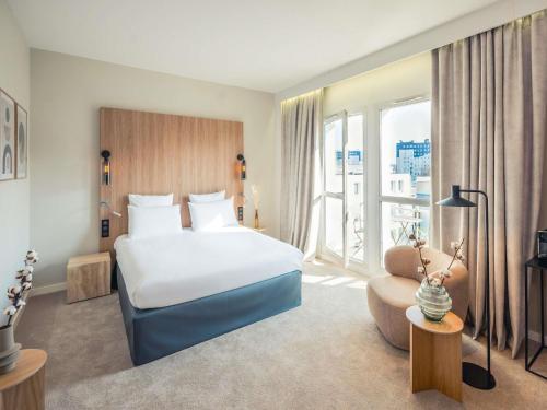 a hotel room with a bed and a large window at Mercure Troyes Centre in Troyes
