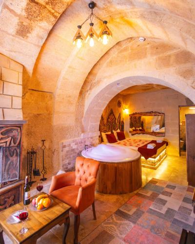 a large room with a bed and a room with a table at Bayar Cave Suites Special Class in Ürgüp