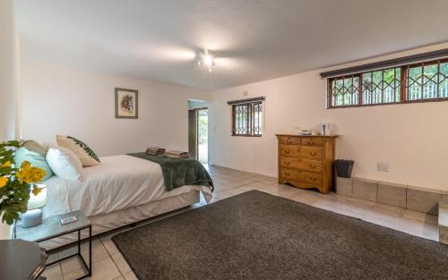 a bedroom with a bed and a dresser and windows at The 3rd Leg Bed and Breakfast in Pennington