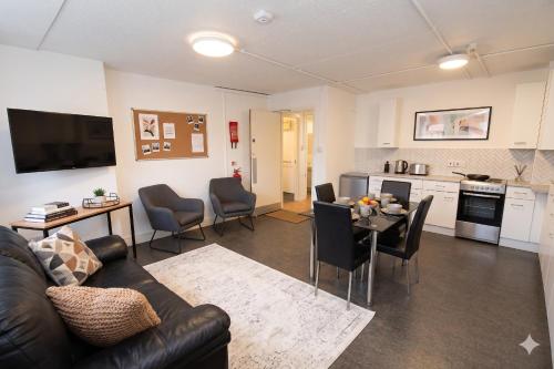 a living room with a couch and a table and a kitchen at Ocean Quay in Greenock