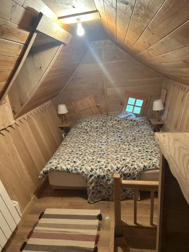 a bedroom with a bed in a wooden attic at Les Jardins de Valinor in Thénezay