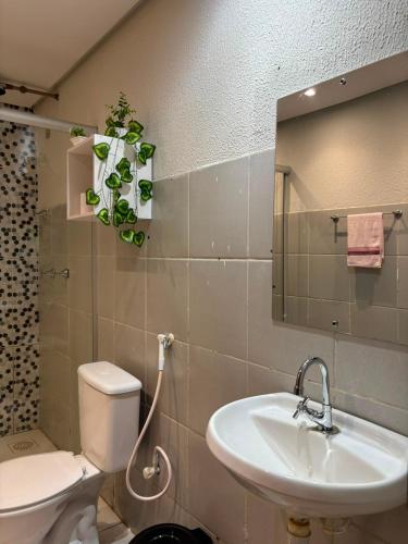 a bathroom with a sink and a toilet and a mirror at RODRIGUES CASA de TEMPORADA em Barreirinhas in Barreirinhas