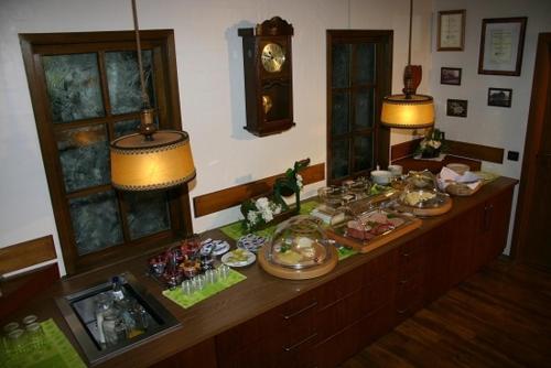 uma mesa com comida com duas lâmpadas e um relógio em Hotel Esinger Hof garni em Tornesch