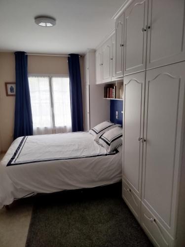a bedroom with a bed and a large white cabinet at maison fleurie in Longué