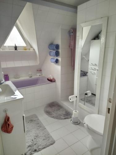 a bathroom with a sink and a tub and a toilet at maison fleurie in Longué