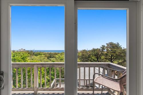 a balcony with a bench and a view of the ocean at Walk to Oceanside Beach in Wellfleet