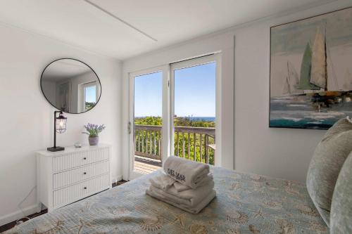a bedroom with a bed with a mirror and a balcony at Walk to Oceanside Beach in Wellfleet