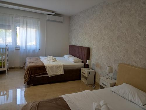 a hotel room with two beds and a window at Apartmani Masline Međugorje in Međugorje