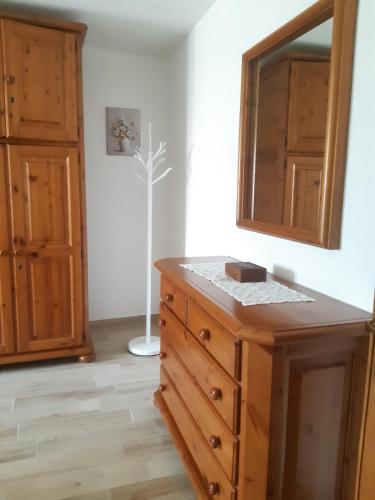 a bathroom with a wooden dresser and a mirror at L'incantevole vista in Colico
