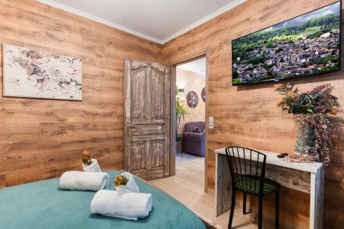 a room with a table and two chairs and a television at Lume in Metsovo