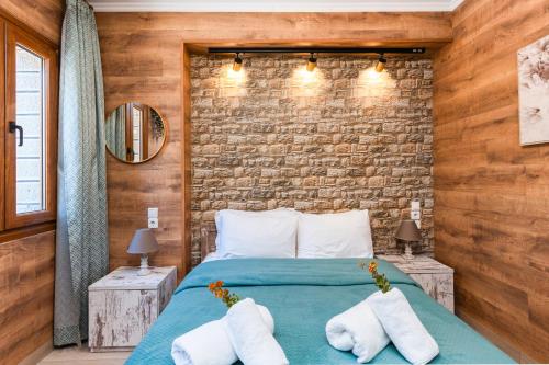 a bedroom with a bed and a brick wall at Lume in Metsovo