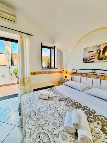a bedroom with two beds and a large window at Il Rifugio Di Ela con 2 appartamenti in Furore