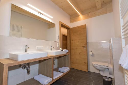 a bathroom with a sink and a toilet and a mirror at Appartements Danijela in Fügenberg