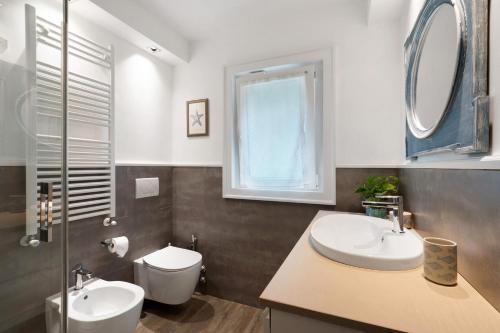 a bathroom with a sink and a toilet and a window at Casa Due Ulivi in Lavagna