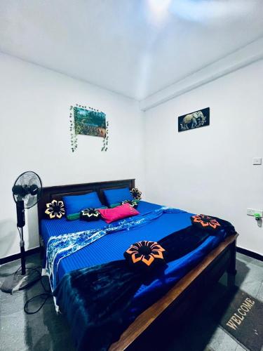 a bedroom with a bed with a blue comforter at Ella Green Breeze in Ella