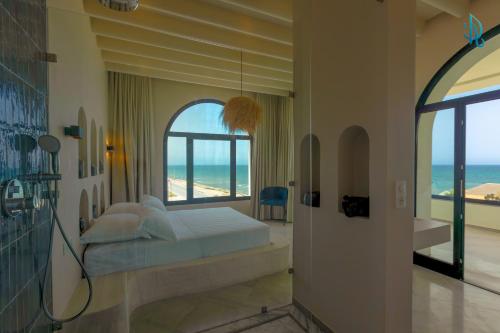 a bedroom with a bed and a view of the ocean at Diar Ayoub in Chebba