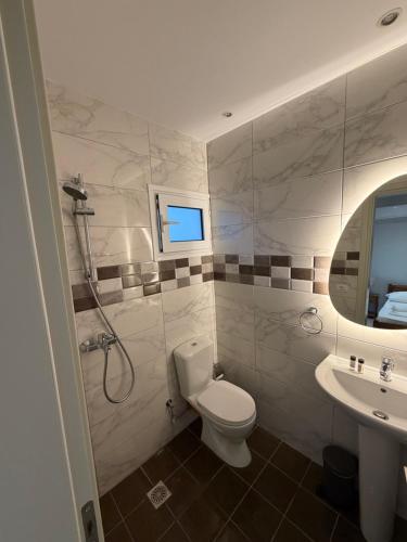 a bathroom with a toilet and a sink at Dhoma Elena in Dhërmi