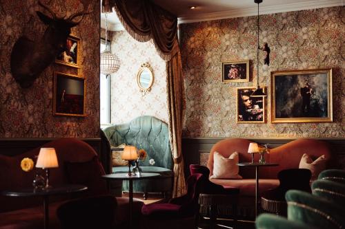 a room with chairs and tables and paintings on the walls at Hotel Pigalle in Gothenburg