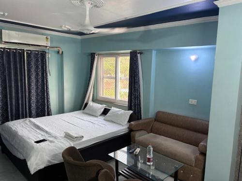 a small room with a bed and a couch at Hotel Surbhi in Shaikhpura