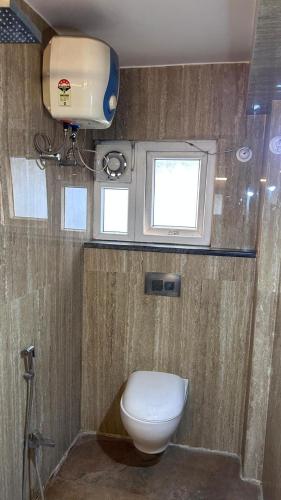 a bathroom with a toilet and a window at Hotel Surbhi in Shaikhpura
