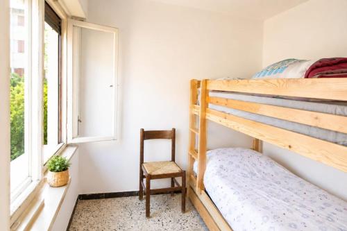 a small bedroom with a bunk bed and a chair at La Dimora del Cadore in Domegge di Cadore
