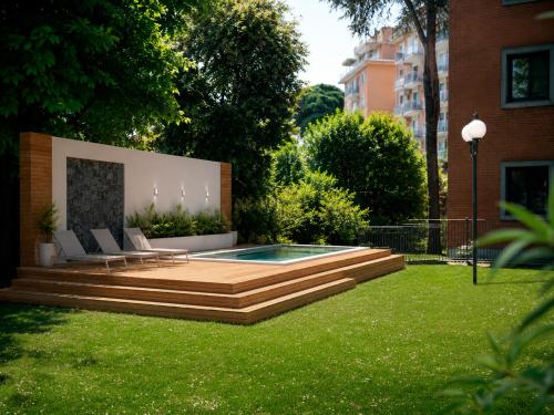 ein Garten mit Swimmingpool und Rasen in der Unterkunft Adoro Hotel in Rom