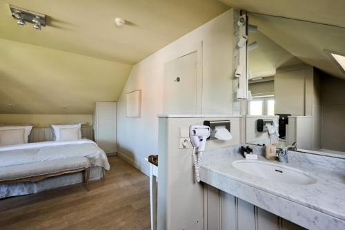 a bathroom with a sink and a bed in a room at Lebeaubylivingroom Hotel in Knokke-Heist