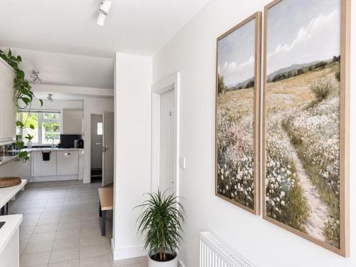 a kitchen and dining room with two paintings on the wall at Spacious En-suite Private Double Bedroom in Oxford