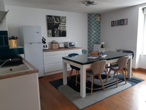 a kitchen with a table and chairs in a kitchen at L'escapade Guingampaise in Guingamp
