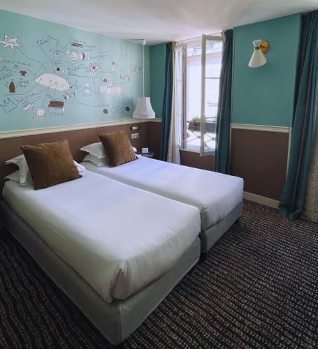 two beds in a hotel room with blue walls at Hôtel des 3 Poussins in Paris