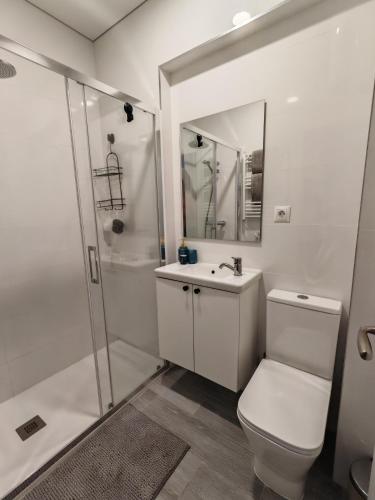 a white bathroom with a toilet and a shower at La Romanilla Garden terrace in Roquetas de Mar