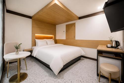 a hotel room with a large bed and a desk at Ramon Hotel in Seoul