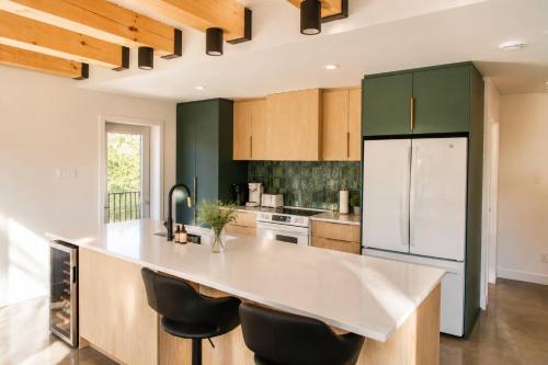 a kitchen with green cabinets and a large kitchen island at Spa & Lake - Orphee in Chertsey