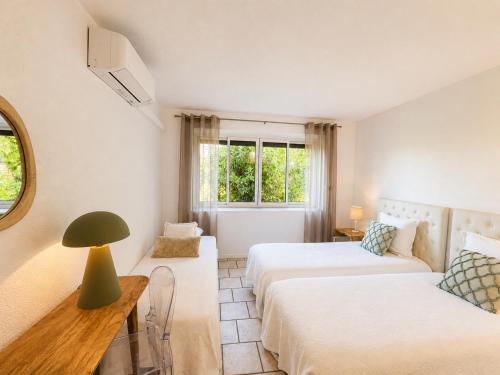 a room with two beds and a table with a lamp at Le Mas du Terme in Barjac