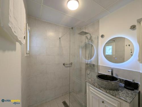 a bathroom with a shower with a sink and a mirror at Chic apart with parking and balcony in Yaoundé